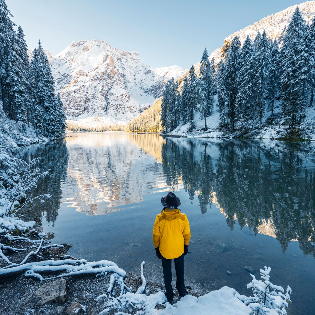 Man looking at lake and snow-covered moutnains