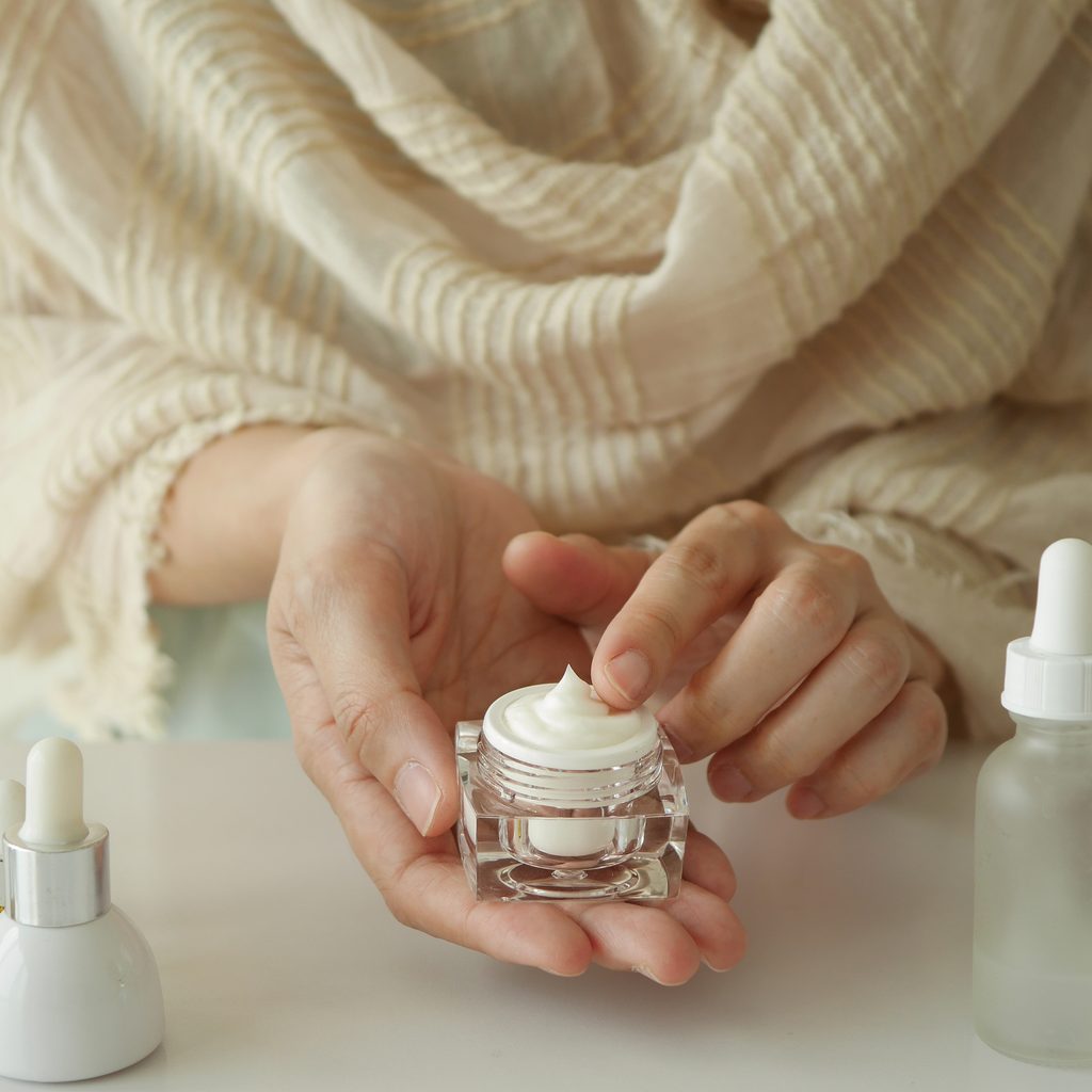 woman's hands holding skincare product