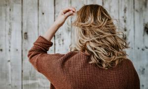 A woman tousling her blonde hair.