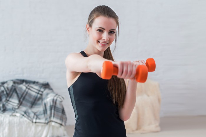 A woman uses boxing exercises to stay fit at home.