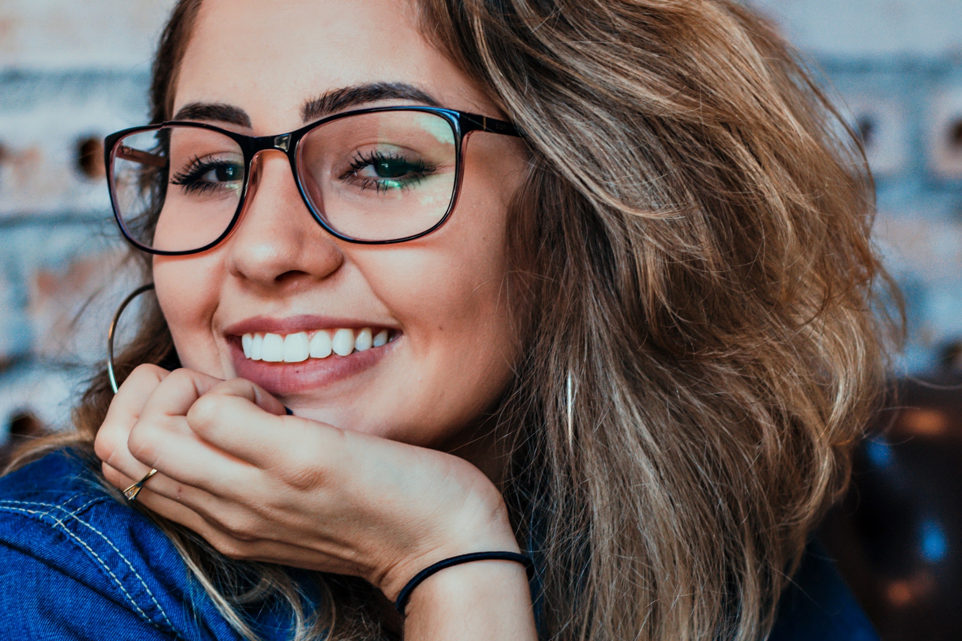 A woman with frizzy hair wearing glasses.