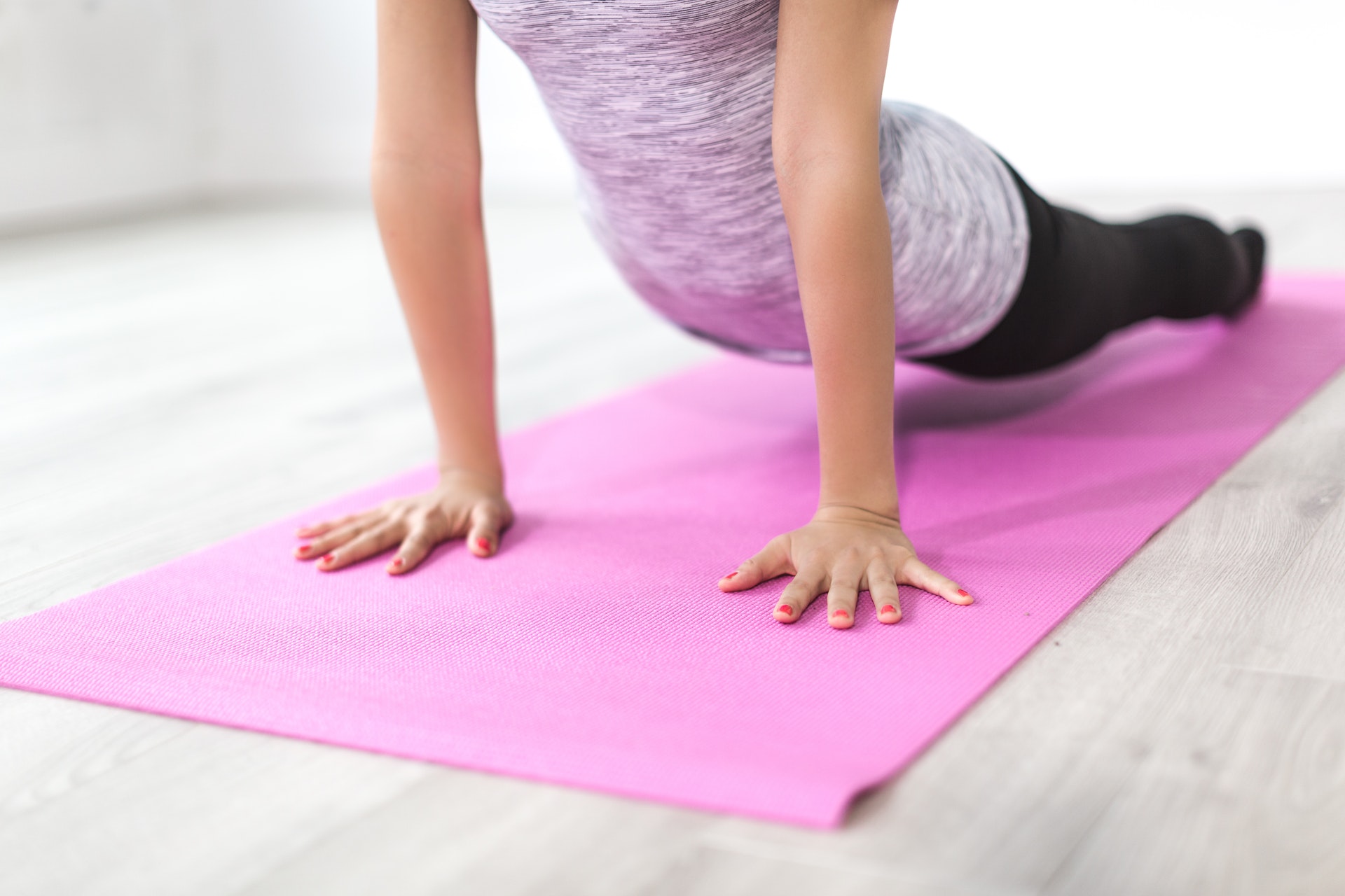 A woman doing yoga on a purple mat.
