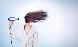 A woman in a bathrobe drying her hair.