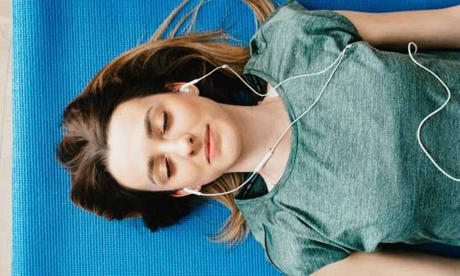 woman listening to music on yoga mat