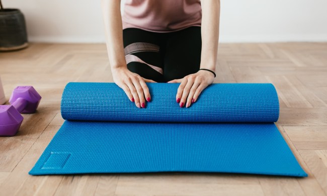 woman unrolling yoga mat
