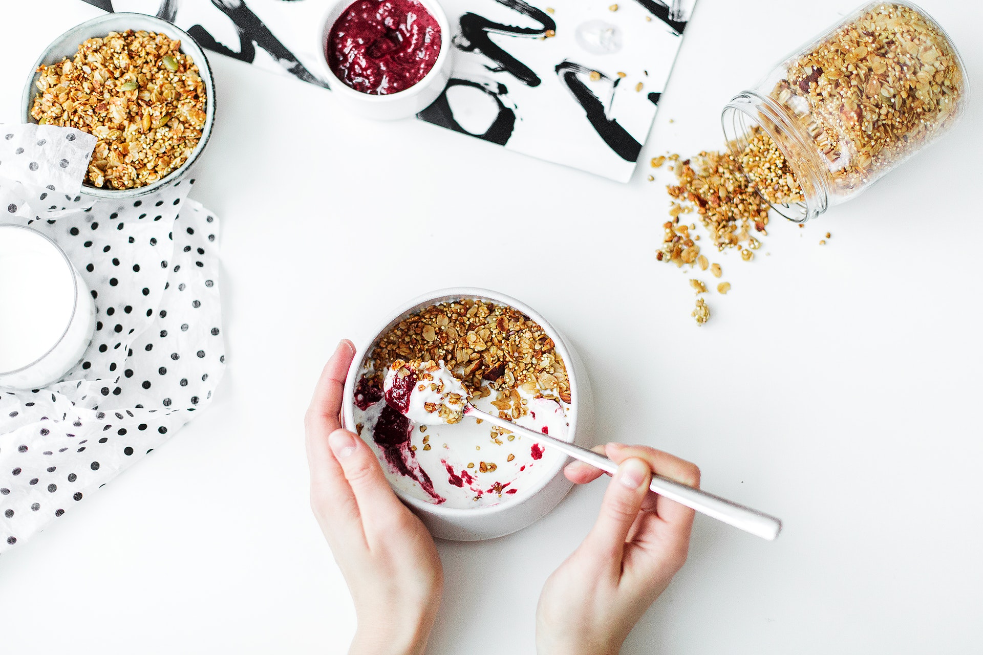 Woman with a bowl of yogurt and granola on a white background.