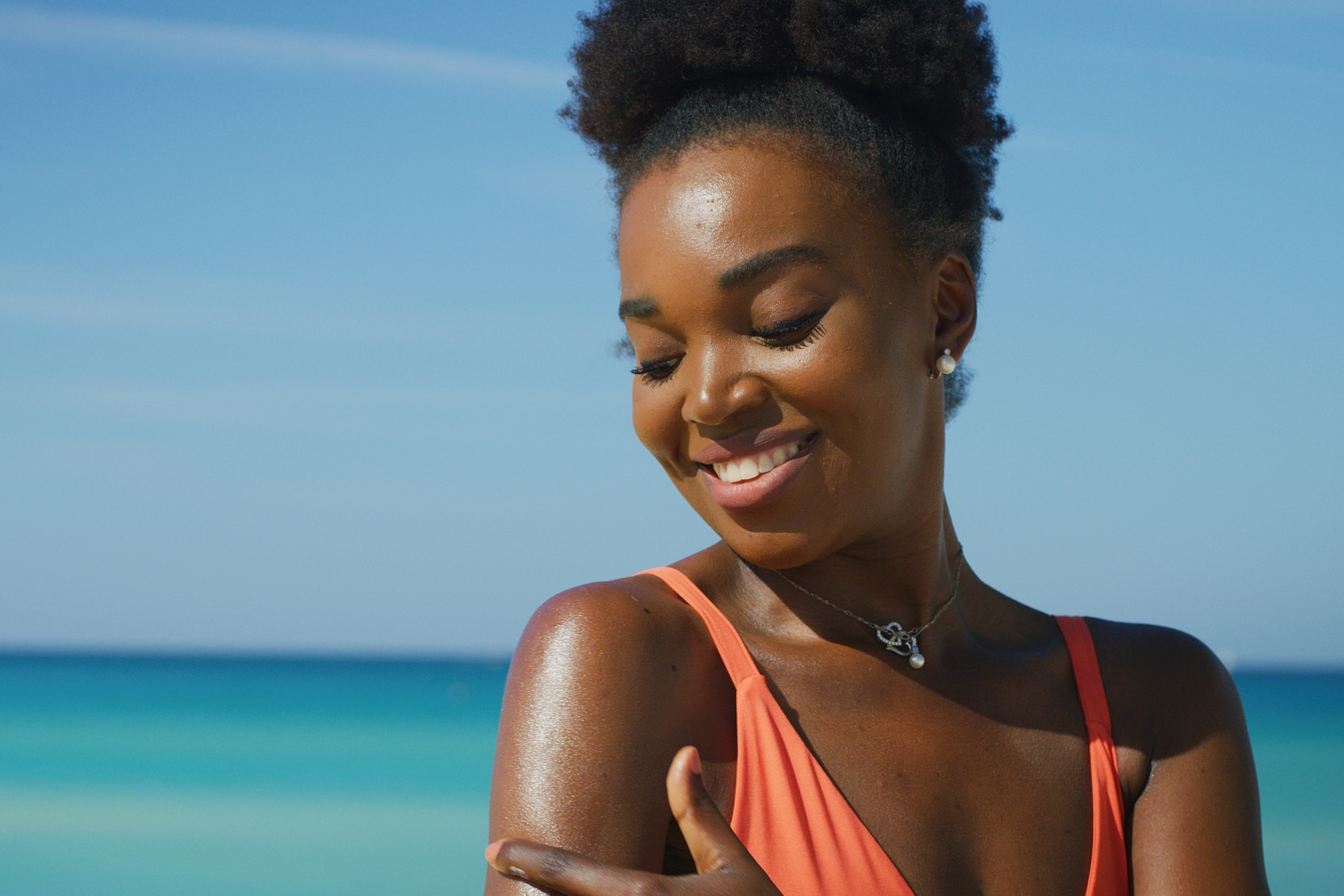 woman applying sunscreen to her skin at the beach
