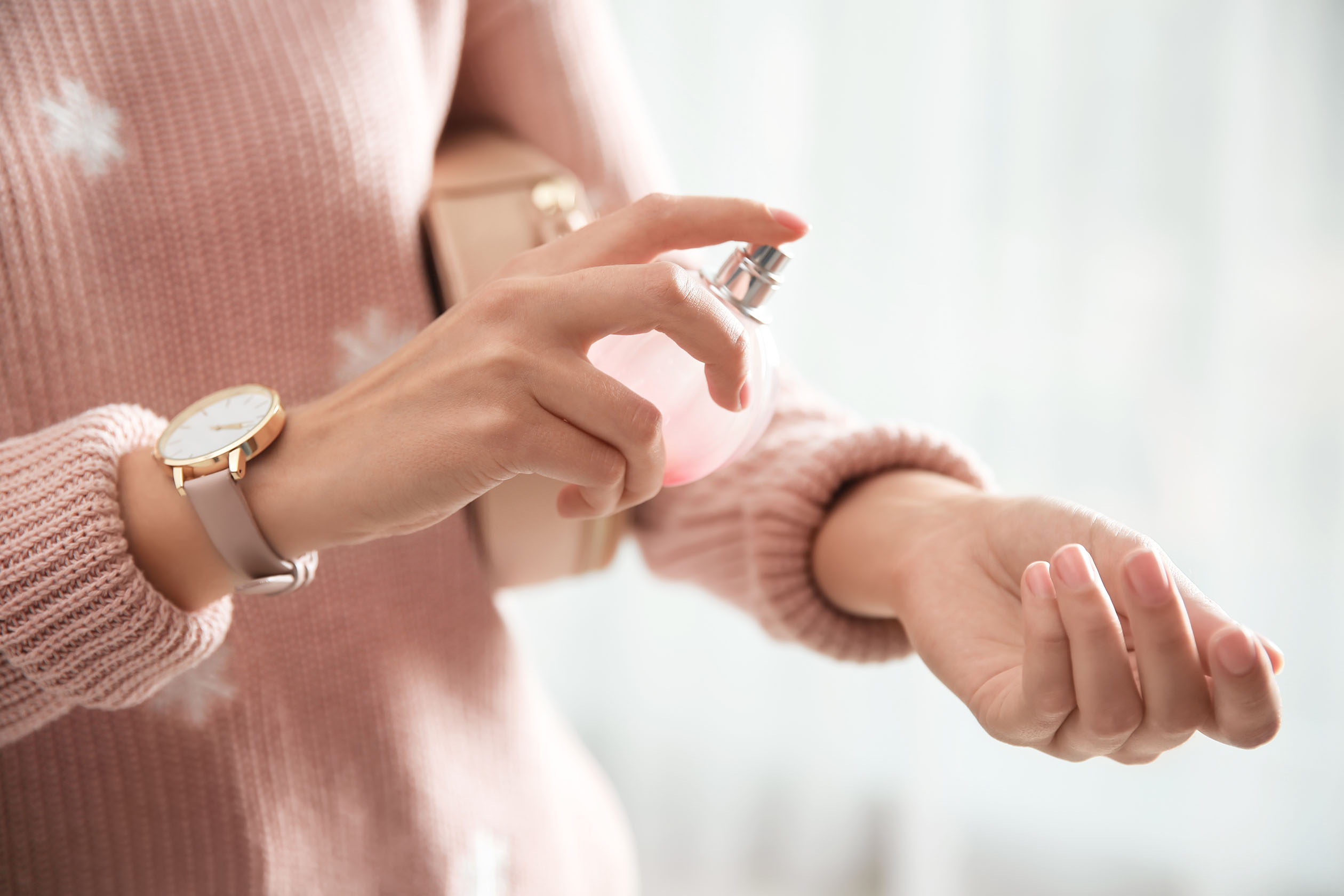 woman applying perfume to wrist