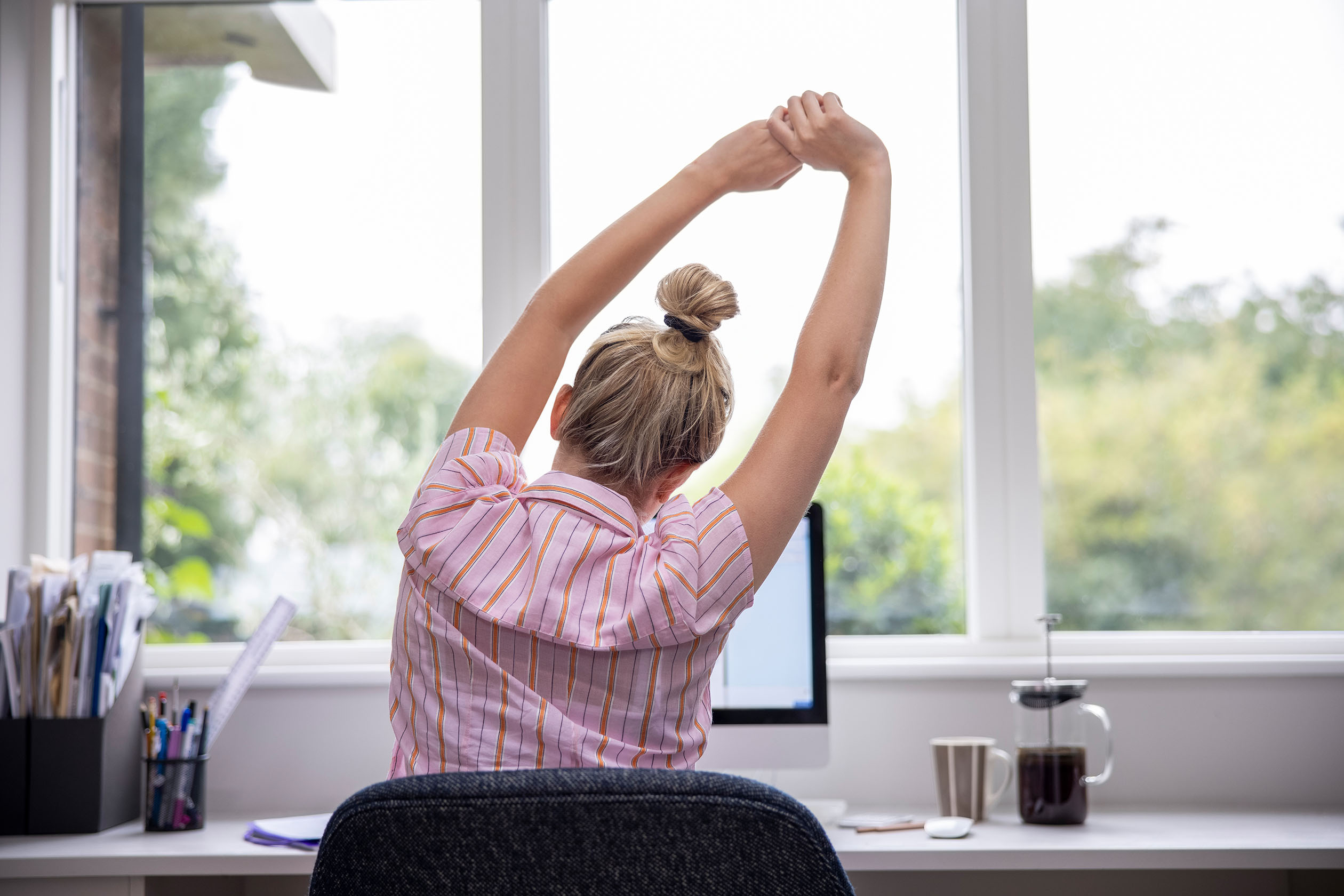 woman stretching at her desk