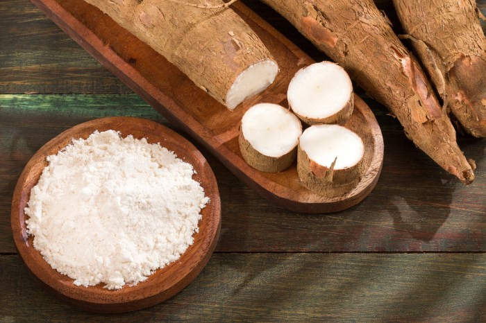 cassava roots beside bowl of cassava flour