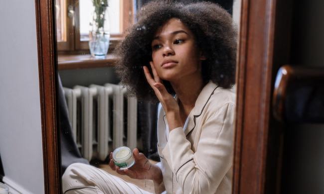 A woman applying a skin care product
