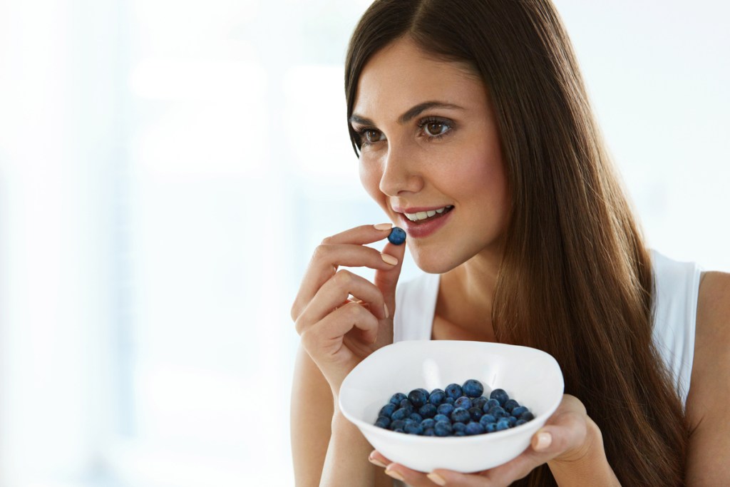 A woman eats blueberries to boost memory