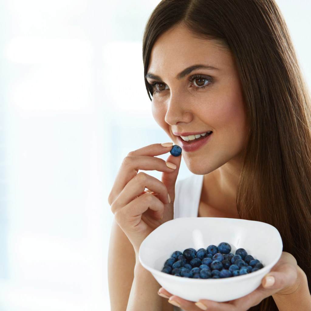 A woman eats blueberries to boost memory