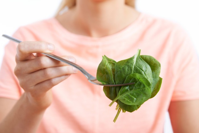 A woman eats spinach