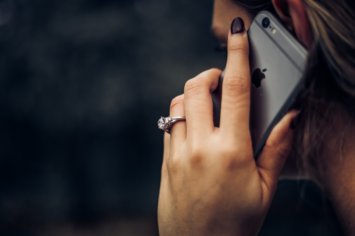 A woman on the phone wearing a wedding ring