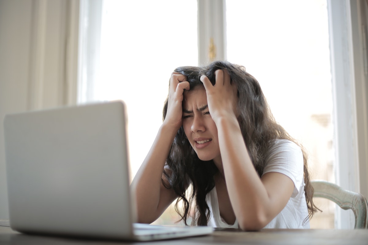 A woman holding her head being stressed out.