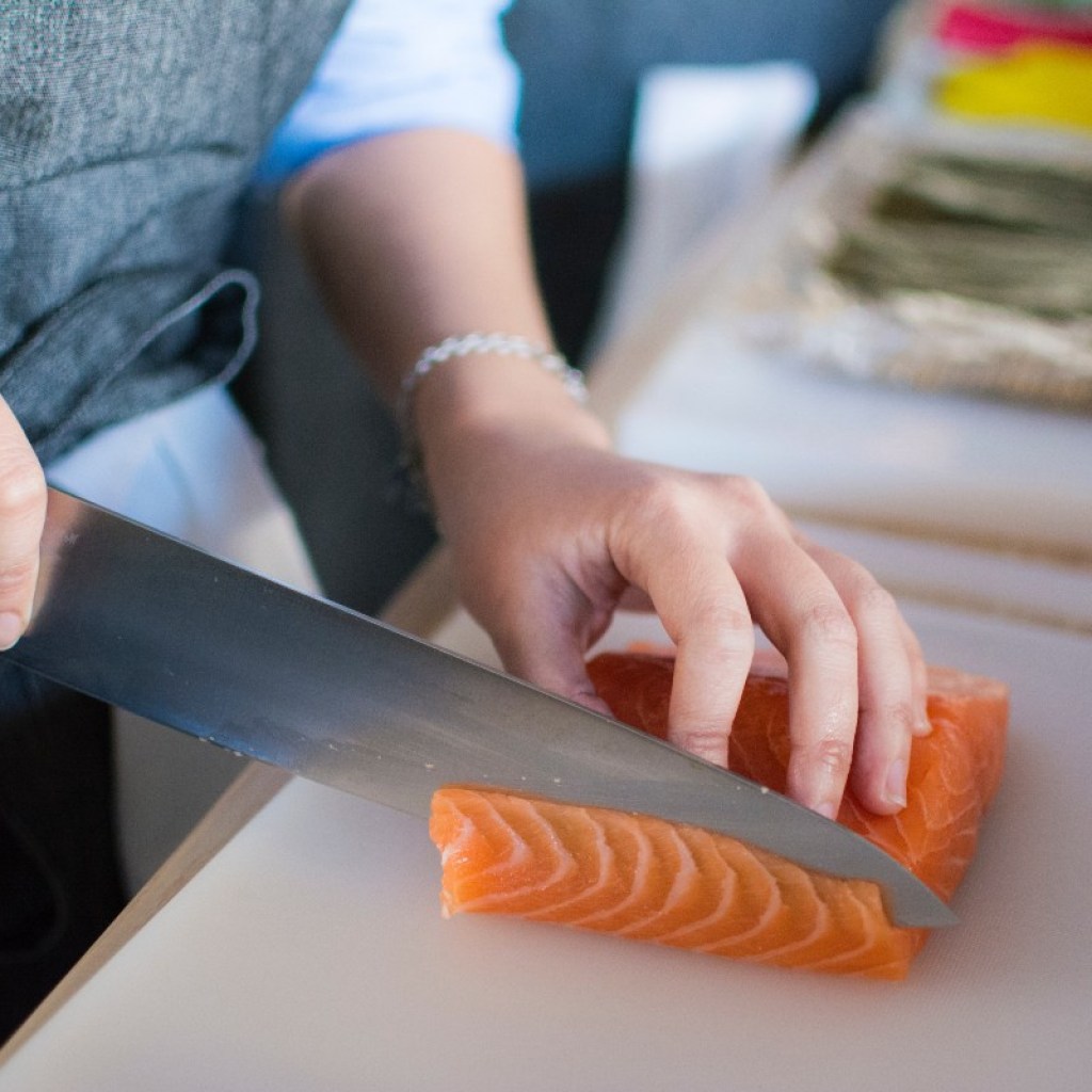 person-cutting-salmon-large-knife