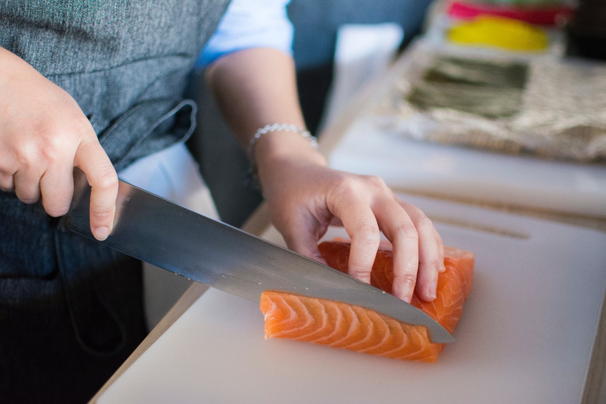 person-cutting-salmon-large-knife