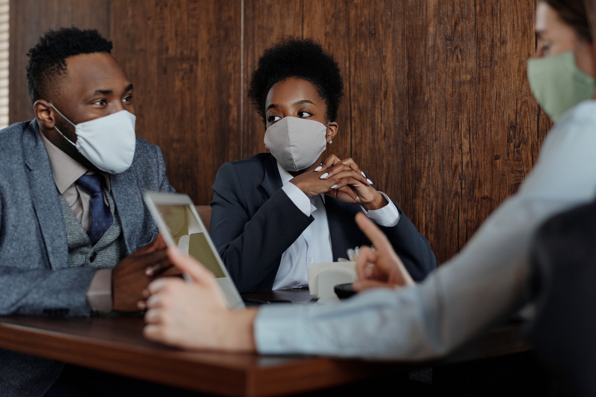 A group of people wearing face masks during a meeting.
