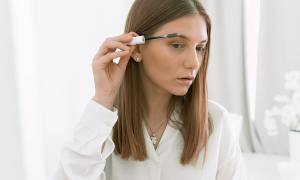 A woman doing her eyebrows.