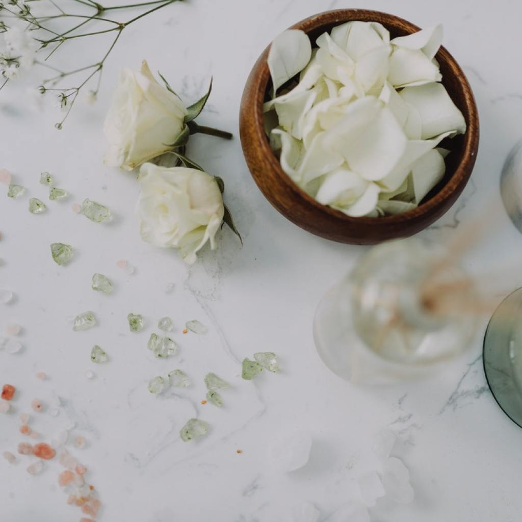 A candle and other relaxing items on a table.