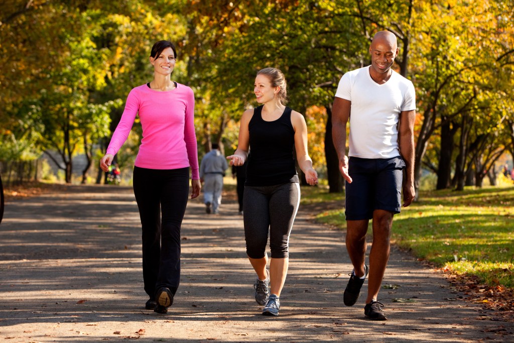 Three people walking in park