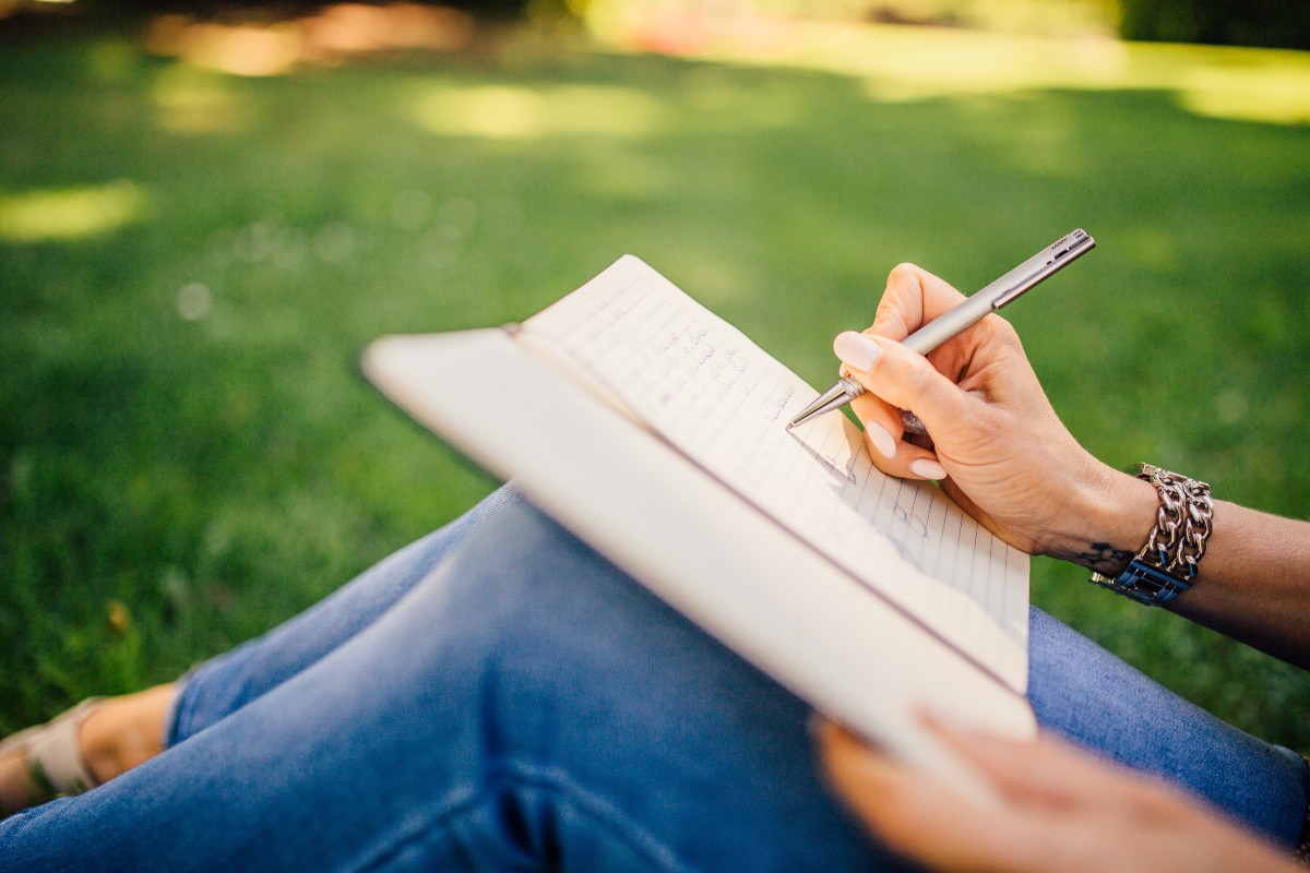 woman-journaling-on-green-grass