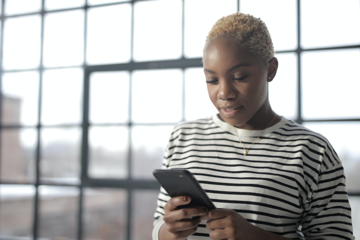 woman-looking-at-phone-near-windows