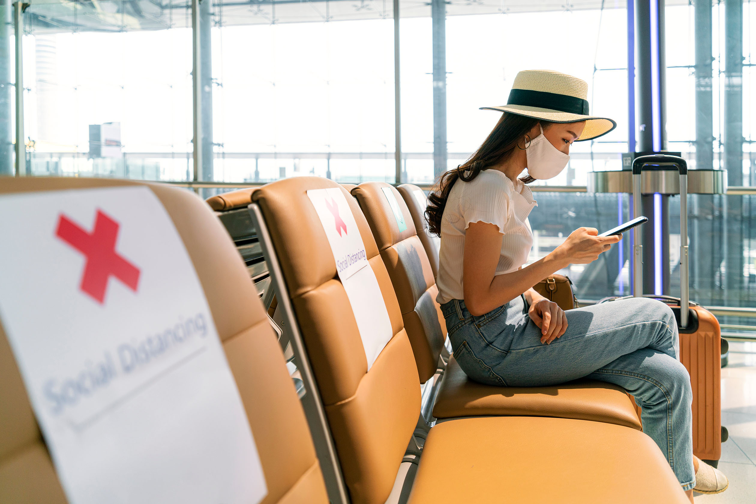 Woman wearing a mask sitting at the airport