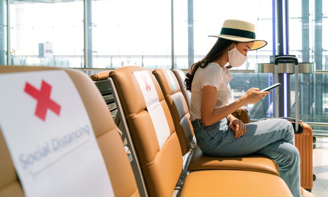 Woman wearing a mask sitting at the airport