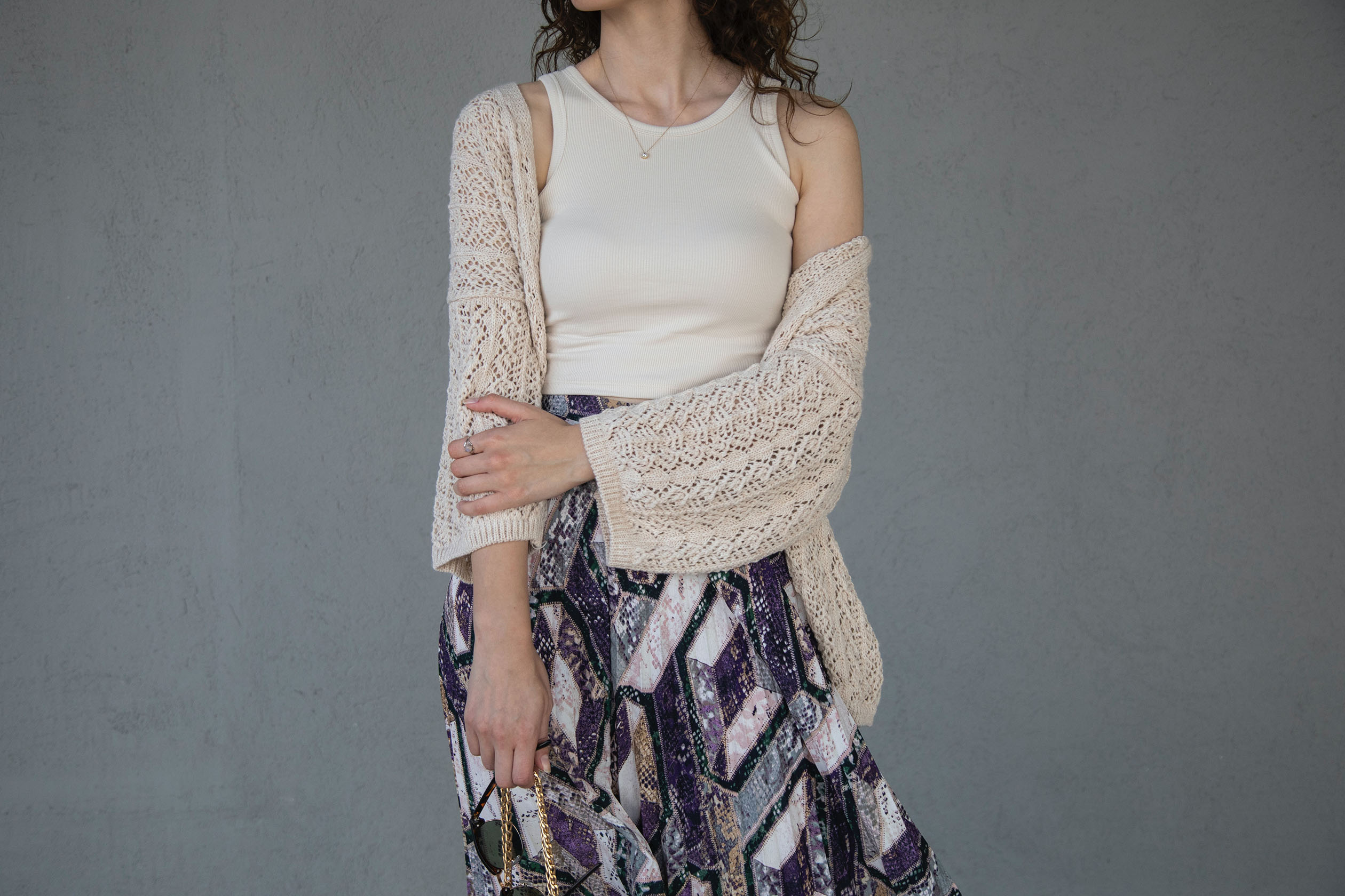 Woman wearing a tank top, cardigan, and boho skirt