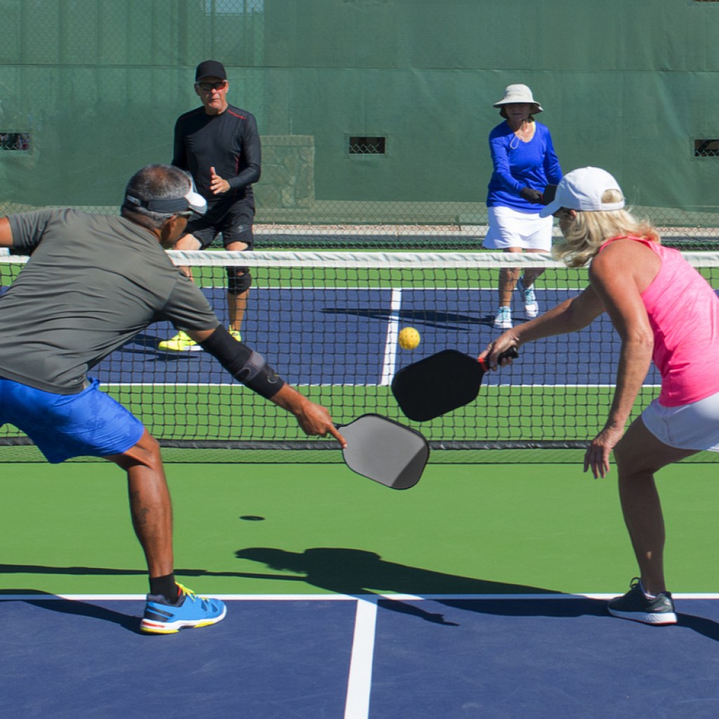 A group plays pickleball