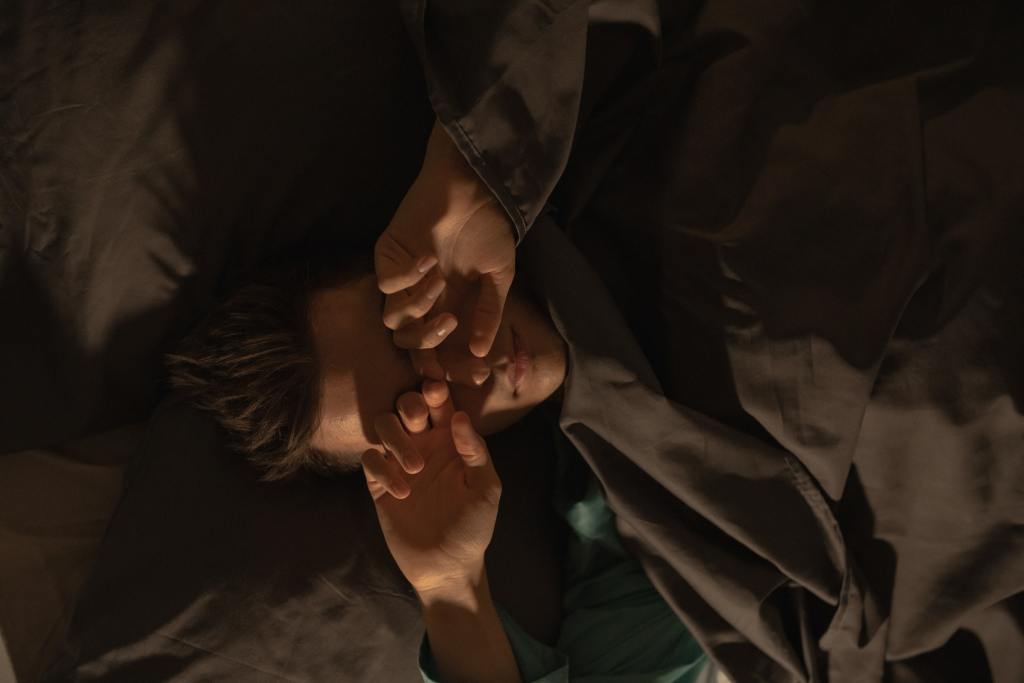 Man in Green Shirt Lying on Bed