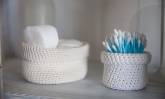 q tips in a white basket on bathroom counter