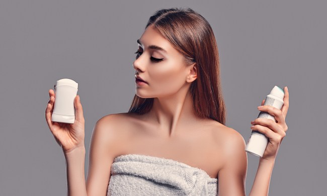 A woman deciding between two different deodorants.