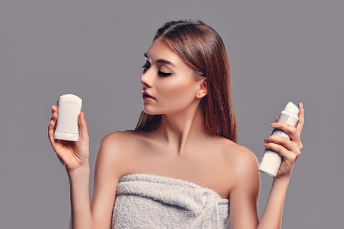 A woman deciding between two different deodorants.