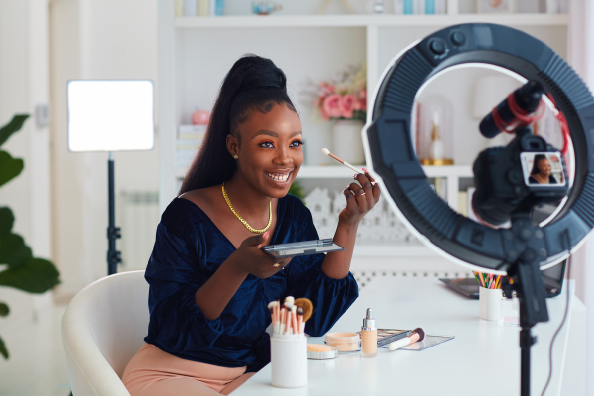 A Black woman is shooting a makeup tutorial video.