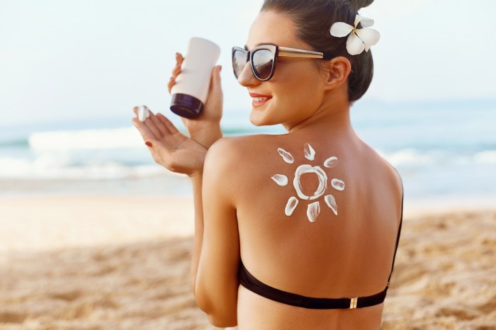 Woman applying sunscreen on the beach