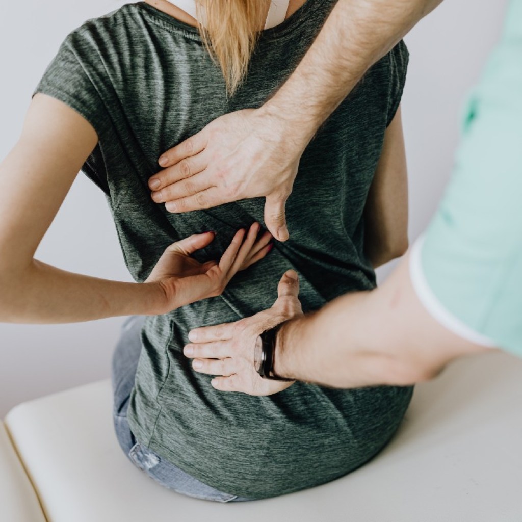 a woman in a green shirt receiving chiropractic care