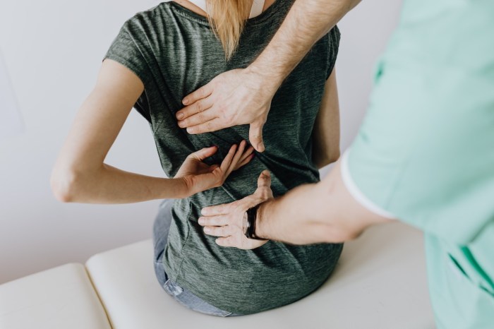 a woman in a green shirt receiving chiropractic care