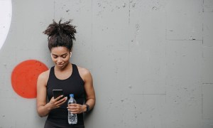 best workout podcasts running woman checking phone
