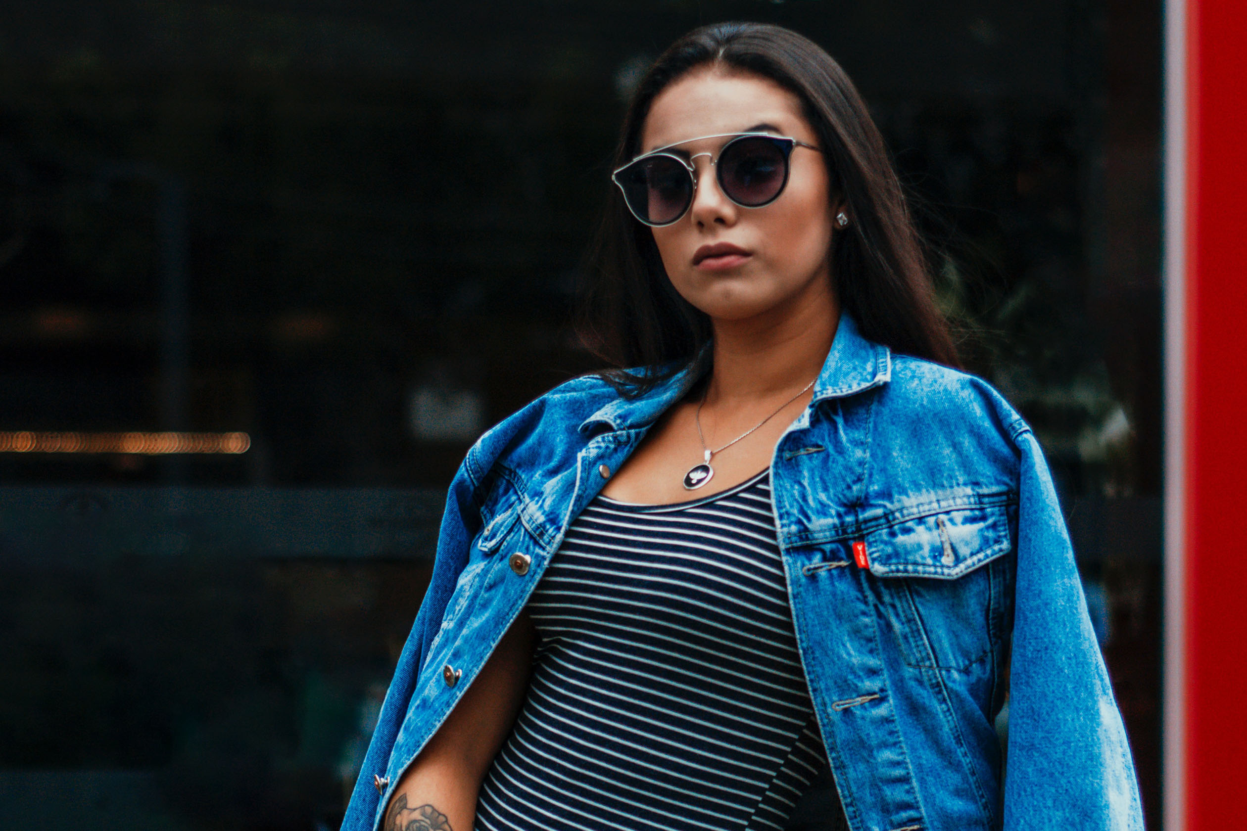 woman in a denim jacket and striped dress