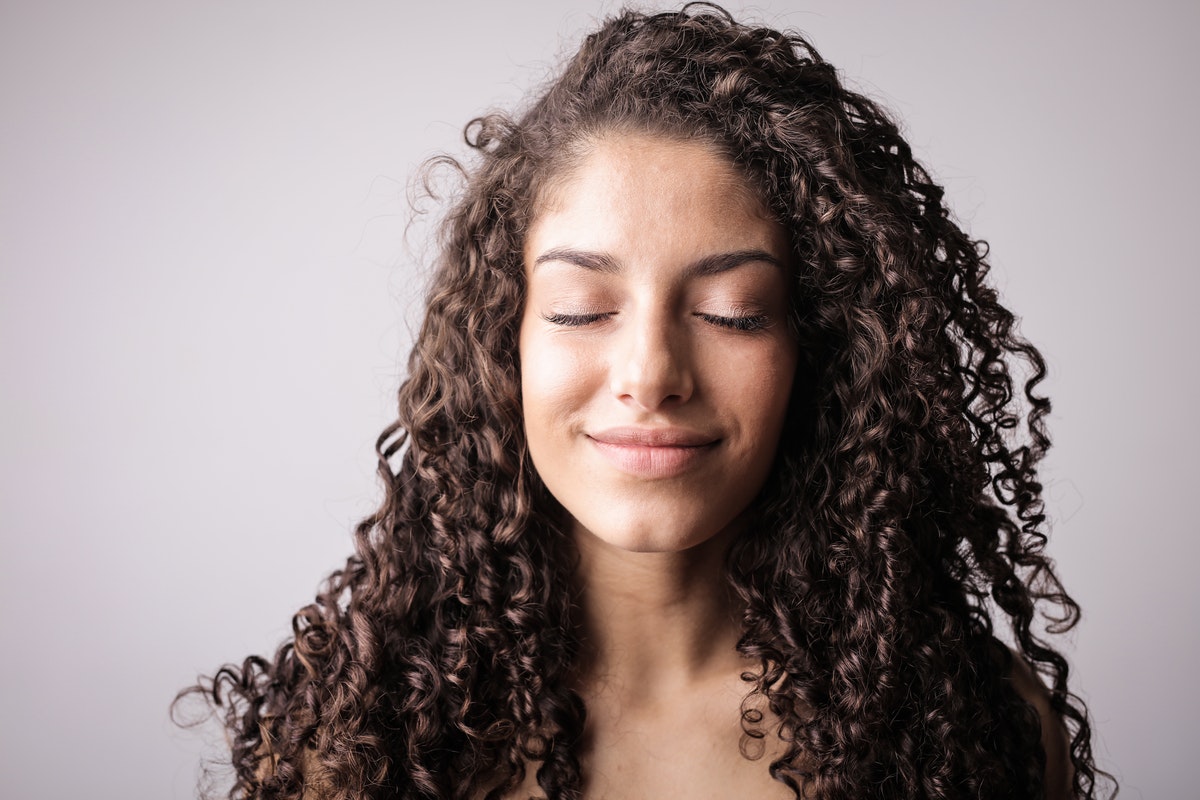 A woman with healthy, long curly hair.