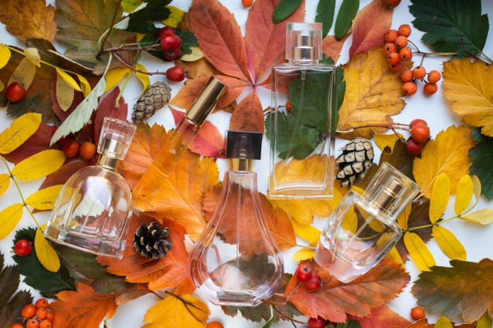 Perfumes laying on a bed of colorful fall leaves.