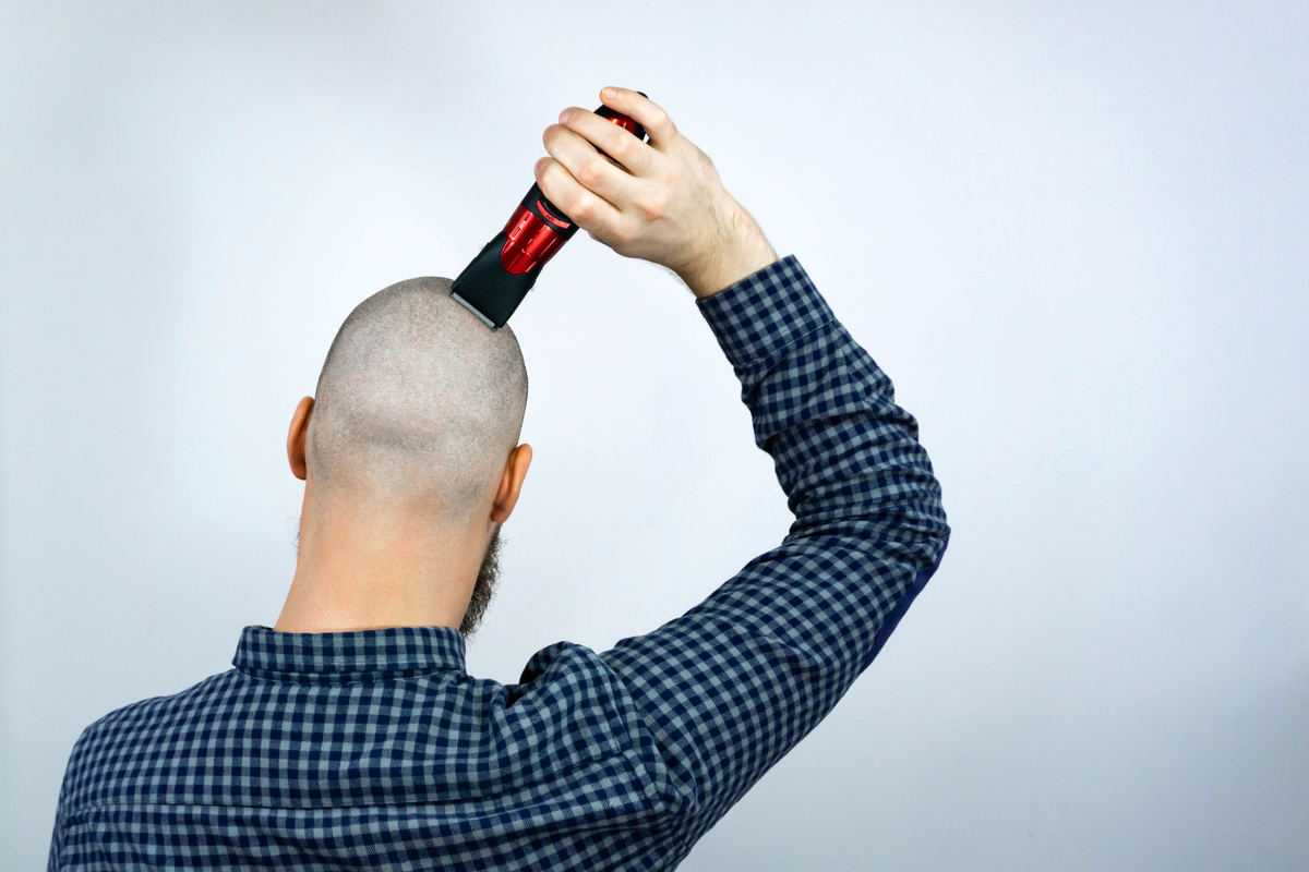 A man shaving his head clippers.