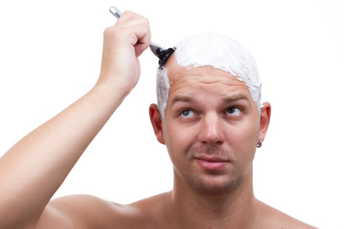 A man shaving his head.