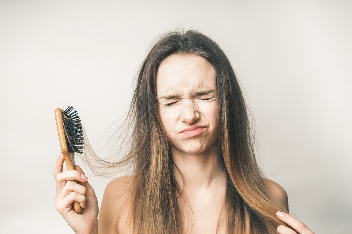A woman brushing her hair too much.