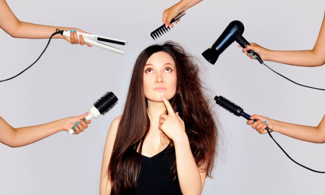 A woman looking at hair care tools that could be damaging her hair.