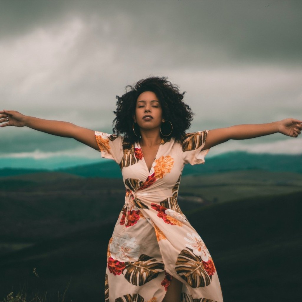 woman in a dress with arms outstretched outside