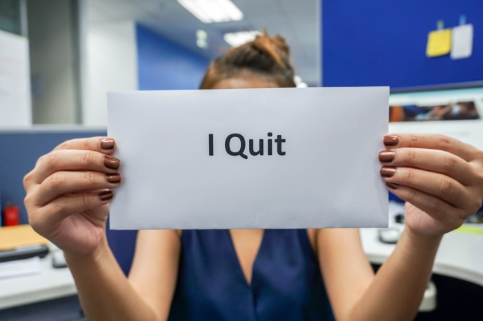 Closeup of woman's hands holding envelope that says "I quit"